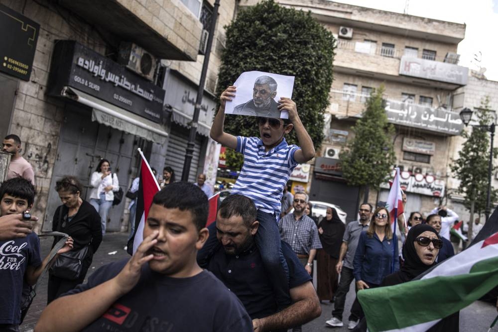 Un joven palestino sostiene un retrato del líder asesinado de Hamás, Yahya Sinwar, durante una manifestación en Ramallah, en OcupieCisjordania, el 18 de octubre de 2024/ Foto John Wessels AFP.,image_description: