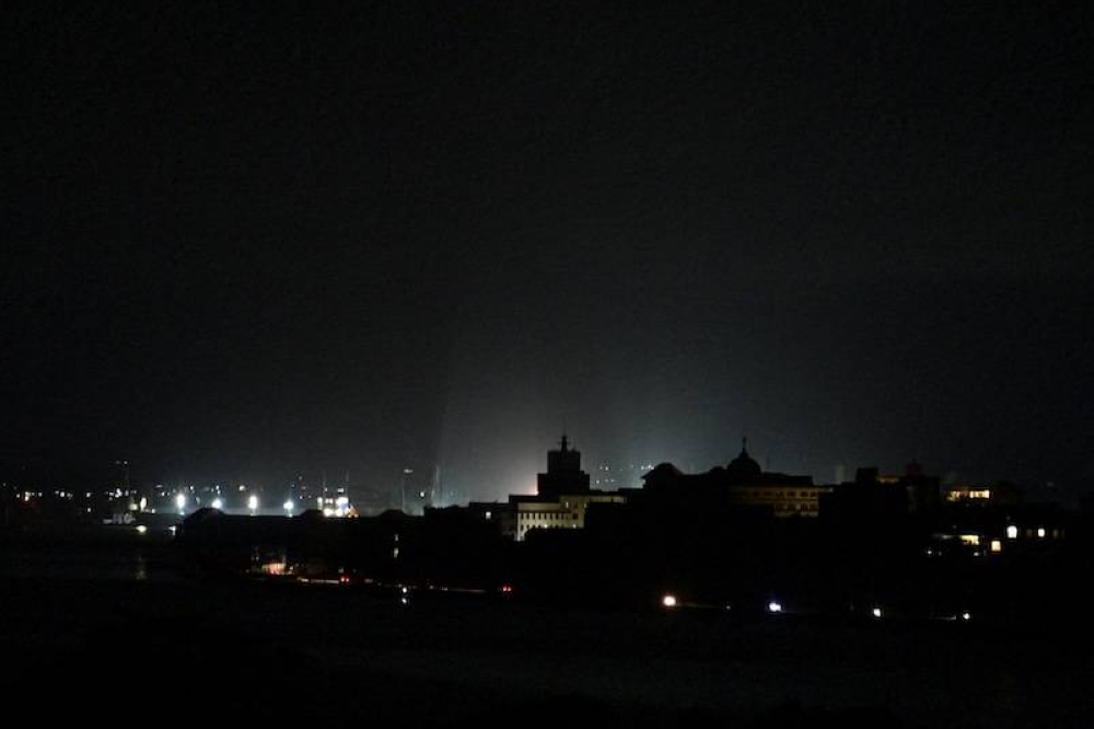 Una vista general del apagón de la noche del viernes 18 de octubre en La Habana. Unos pocos edificios de la ciudad tienen electricidad por generadores./Adalberto ROQUE / AFP,image_description: