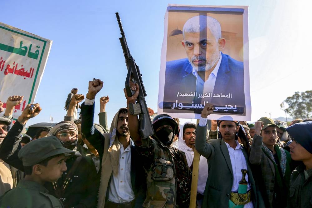 Partidarios de los hutíes de Yemen corean consignas mientras se reúnen con una foto del líder asesinado de Hamás, Yahya Sinwar, durante una manifestación celebrada en la capital, Saná, controlada por los hutíes. /AFP,image_description: