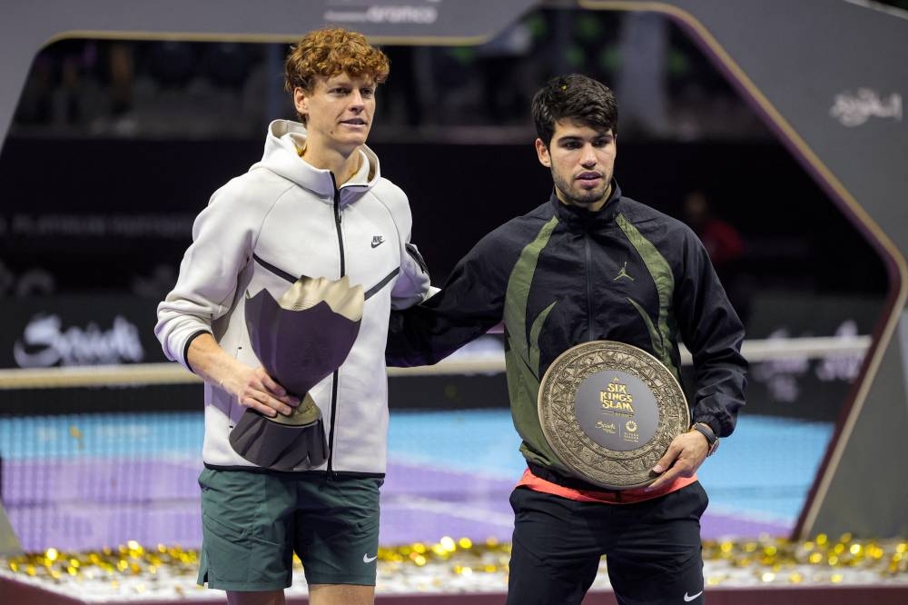 Jannik Sinner, con el premio de campeón, al lado de Carlos Alcaraz. / AFP,image_description:Tennis: 6 Kings Slam exhibition tournament