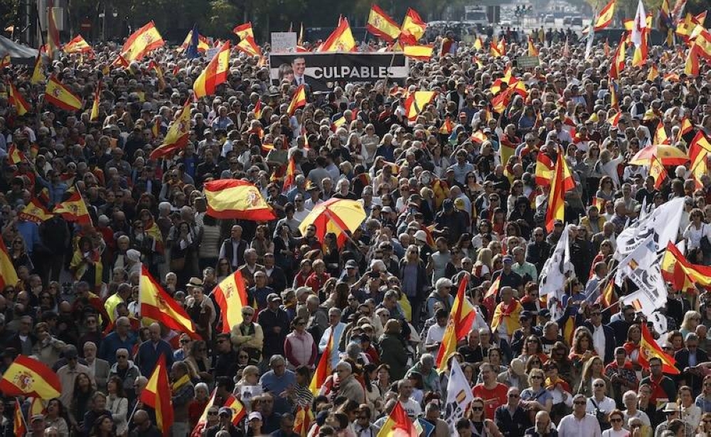 Una pancarta que representa al presidente del Gobierno español, Pedro Sánchez, y a su esposa, Begoña Gómez, junto a la palabra culpable se ve entre banderas españolas durante una manifestación para protestar contra el gobierno gobernante y exigir elecciones generales, en Madrid el 20 de octubre de 2024. Miles de personas llenaron una plaza de Madrid el domingo para protestar contra el gobierno del primer ministro socialista Pedro Sánchez y exigir elecciones anticipadas, en una
                            </a>
                        </div>
                        <div class=