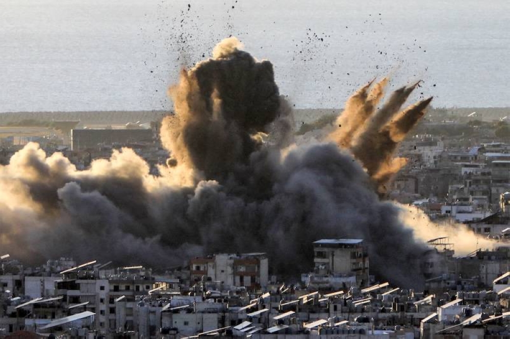 Una nube de humo estalla tras un ataque aéreo israelí en los suburbios del sur de Beirut el 19 de octubre. Israel amplió sus operaciones en el Líbano casi un año después de que Hezbolá comenzara a intercambiar disparos en apoyo de su aliado, Hamás, tras el mortal ataque del grupo palestino a Israel el 7 de octubre de 2023./AFP,image_description: