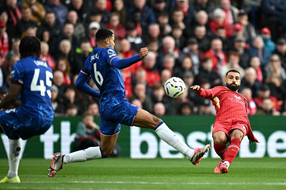 Mohamed Salah intenta rematar ante la marca rival. / AFP ,image_description: