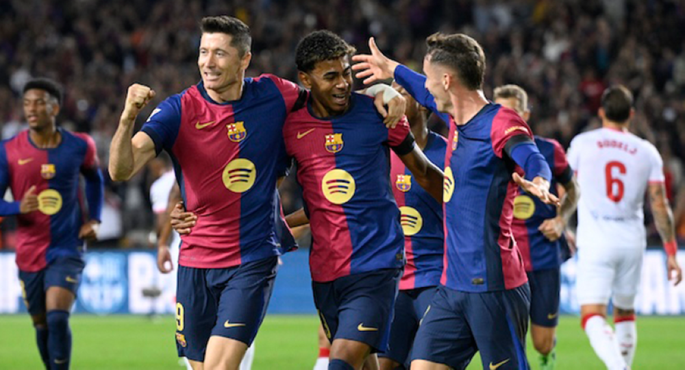 El delantero polac del Barcelona, u200bu200bRobert Lewandowski izq., celebra el primer gol desde el punto de penalti durante el partido de fútbol de la liga española entre el FC Barcelona y el Sevilla FC en el Estadi Olimpic Lluis Companys en Barcelona el 20 de octubre de 2024./ AFP,image_description: