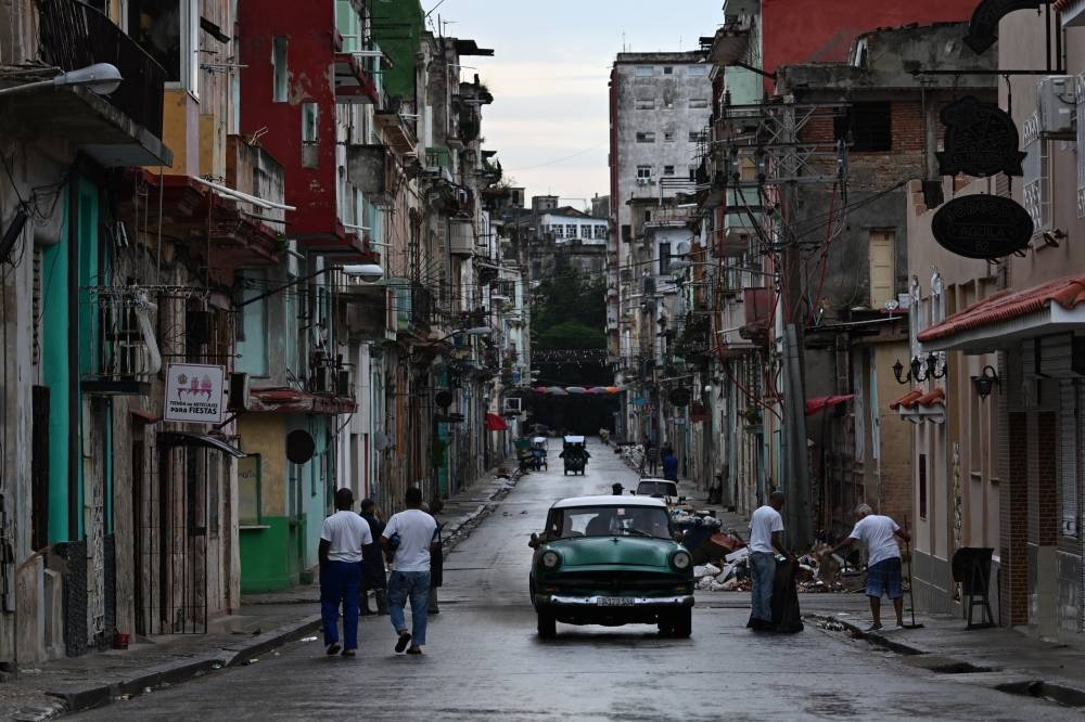 La electricidad se ha restablecido en la mitad de La Habana, informó el lunes la compañía eléctrica de la capital cubana, cuatro días después del inicio de un apagón nacional que las autoridades han tenido dificultades para solucionar. Foto de YAMIL LAGE / AFP,image_description: