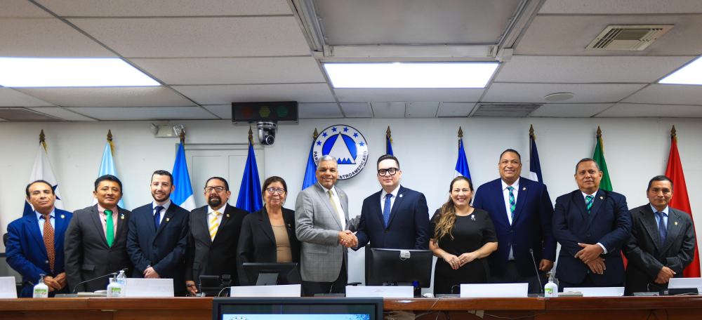 El presidente del Parlacen, el dominicano Ramón Emilio Gori, saluda a su sucesor, el salvadoreño Carlos Hernández, quien asumirá su cargo el 28 de octubre de 2024. / PARLACEN.,image_description: