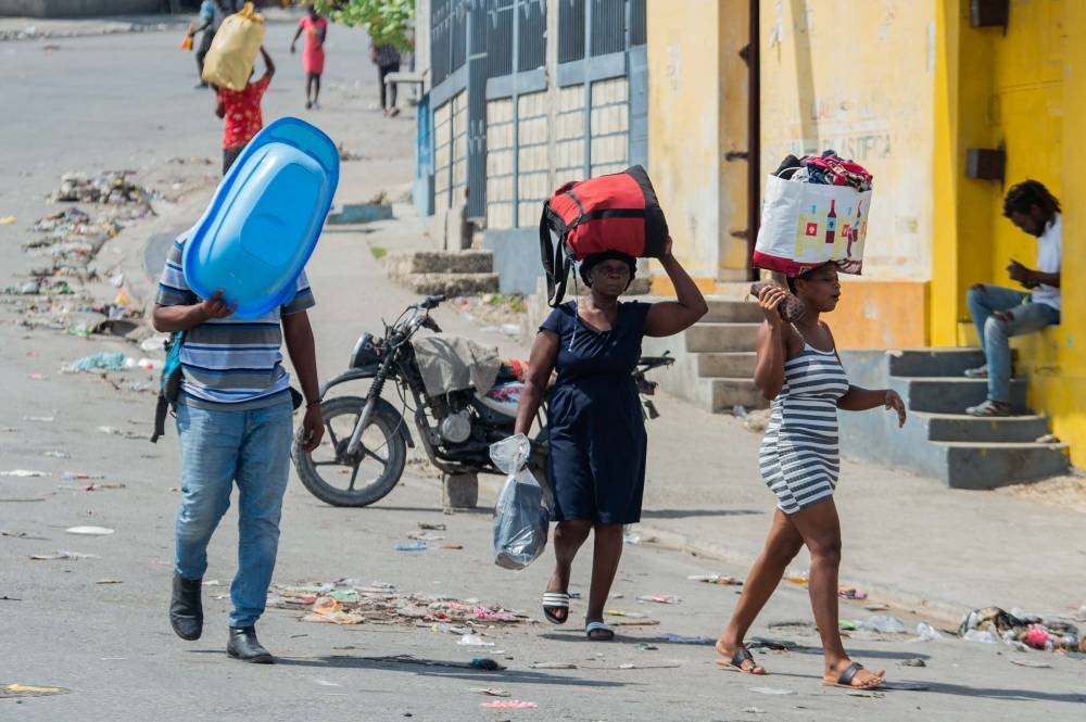 La gente huye de su barrio después de que bandas armadas aterrorizaran las zonas de Delmas 24 y Solino, en Puerto Príncipe, Haití. / AFP.,image_description:Haiti gripped by gang violence crisis