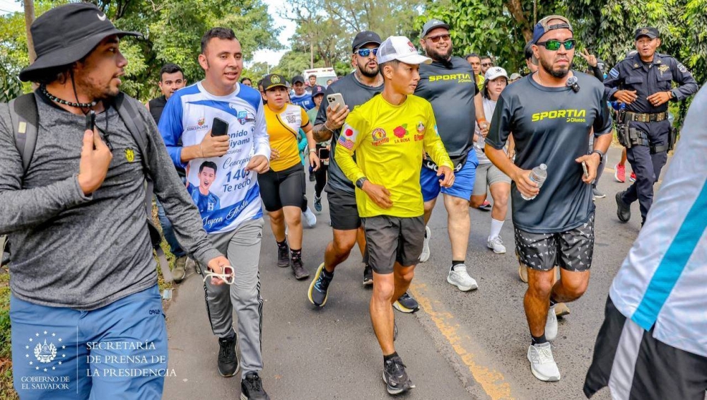 Shian Fujiyama iniciando su recorrido en Lourdes, rodeado de varios admiradores, entre ellos, creadores de contenido y atletas. Créditos: Secretaria de Prensa de la Presidencia.,image_description: