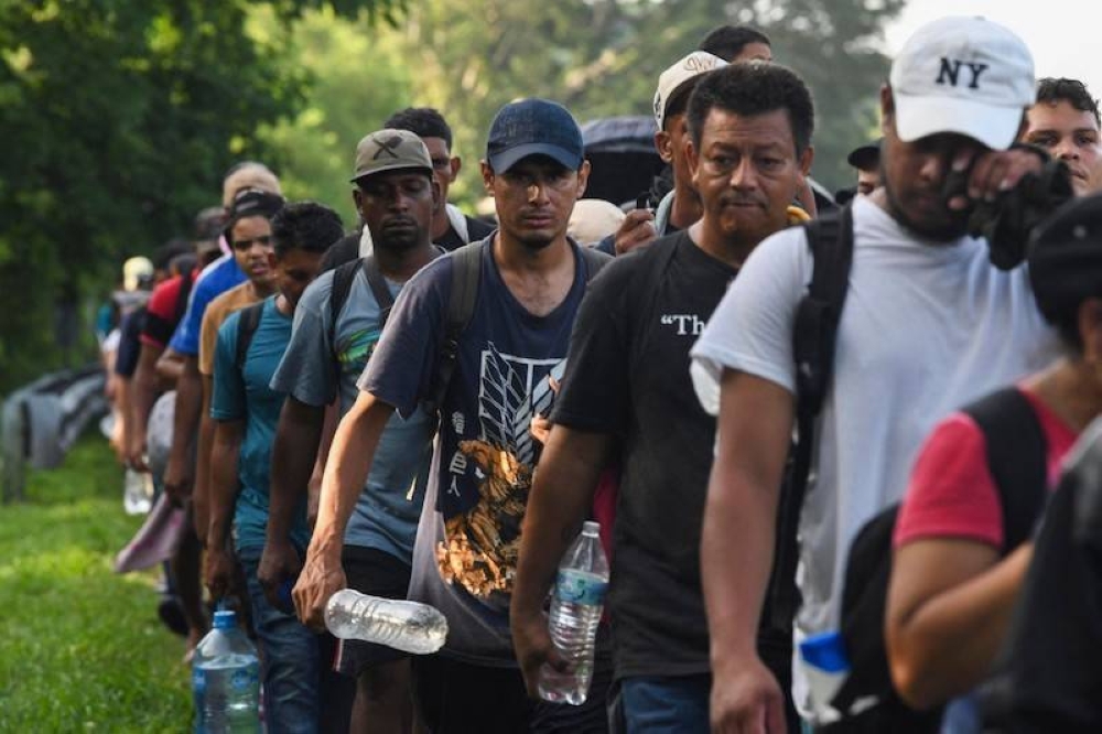 Migrantes de Centroamérica y Venezuela caminan hacia EEUU en Chiapas, México, el 24 de julio de 2024. / AFP.,image_description: