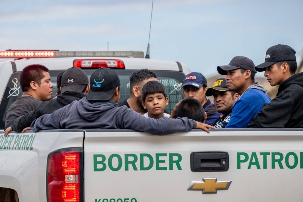 Migrantes que buscan asilo después de ser detenidos por agentes de CBP después de cruzar ilegalmente a los EE. UU. el 24 de junio en Ruby, Arizona. / AFP.,image_description: