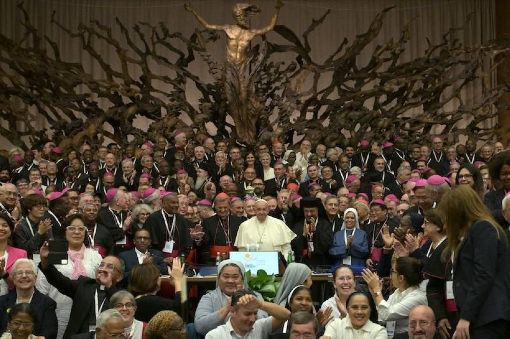 El papa Francisco durante una de las sesiones del Síndo de Obispos en El Vaticano, rodeado de los participantes./AFP  ,image_description: