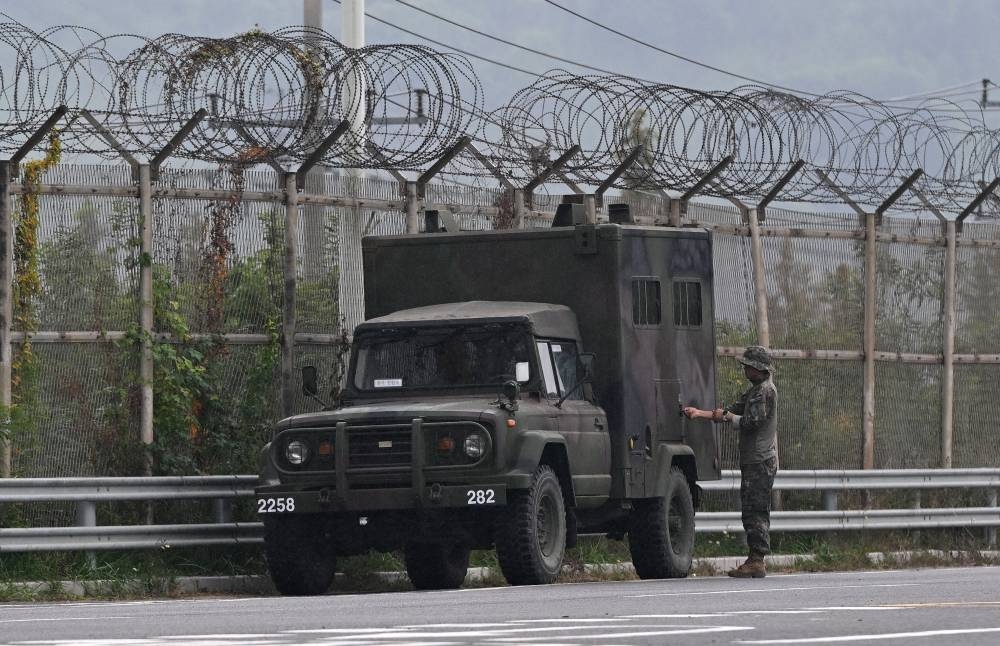 La agencia surcoreana de espionaje dijo a legisladores que incluso generales norcoreanos podrían trasladarse a zonas fronterizas, en una señal de la intensificación de la cooperación entre Moscú y Pyongyang. /Imagen ilustrativa de AFP de un camión y un soldados Norcoreano n,image_description: