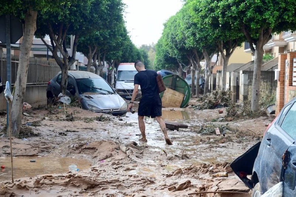 Un hombre camina por una calle cubierta de barro en una zona inundada en Picanya, cerca de Valencia, en el este de España, el 30 de octubre de 2024. Las inundaciones provocadas por las lluvias torrenciales en la región de Valencia, han dejado 62 zpersonas muertas, dijeron los servicios de rescate./AFP ,image_description: