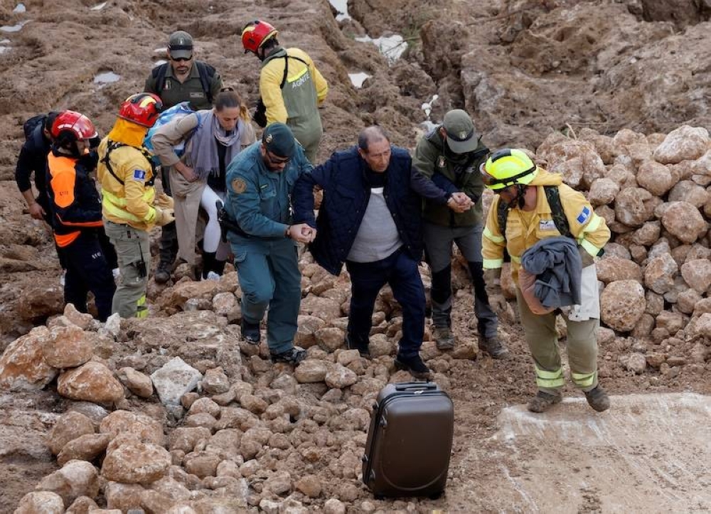 El personal de los servicios de emergencia ayuda a un hombre tras las inundaciones mortales en Letur, al suroeste de Valencia, en el este de España, el 30 de octubre de 2024.  Las inundaciones provocadas por las lluvias torrenciales en la región de Valencia, en el este de España, han dejado al menos 95 personas muertas, dijeron los servicios de rescate./AFP,image_description: