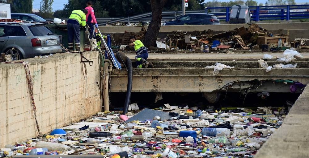 Los escombros flotan sobre el agua en un túnel inundado mientras los trabajadores usan tubos para bombearlos después de una inundación mortal en Alfafar, en la región de Valencia, este de España, el 4 de noviembre de 2024/ José Jordán AFP.,image_description: