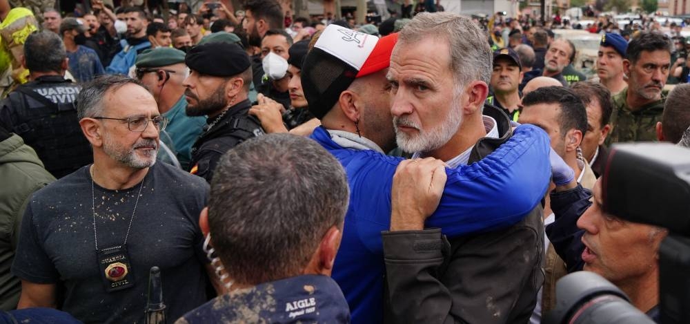 El rey Felipe VI de España derecha es abrazado por un hombre mientras otros residentes enojados lo abucheaban durante su visita a Paiporta, en la región de Valencia, este de España, el 3 de noviembre de 2024/ Foto Manaure Quintero AFP.,image_description: