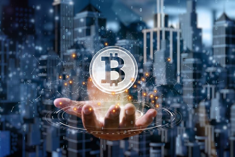 Bitcoin podría no caer a menos de 60,000, explicó el economista y personalidad del internet, Alex Kru00fcger,,image_description:Businessman is holding a bitcoin as part of a business network, Cryptocurrency blockchain connection, Technology and financial investment background concept.