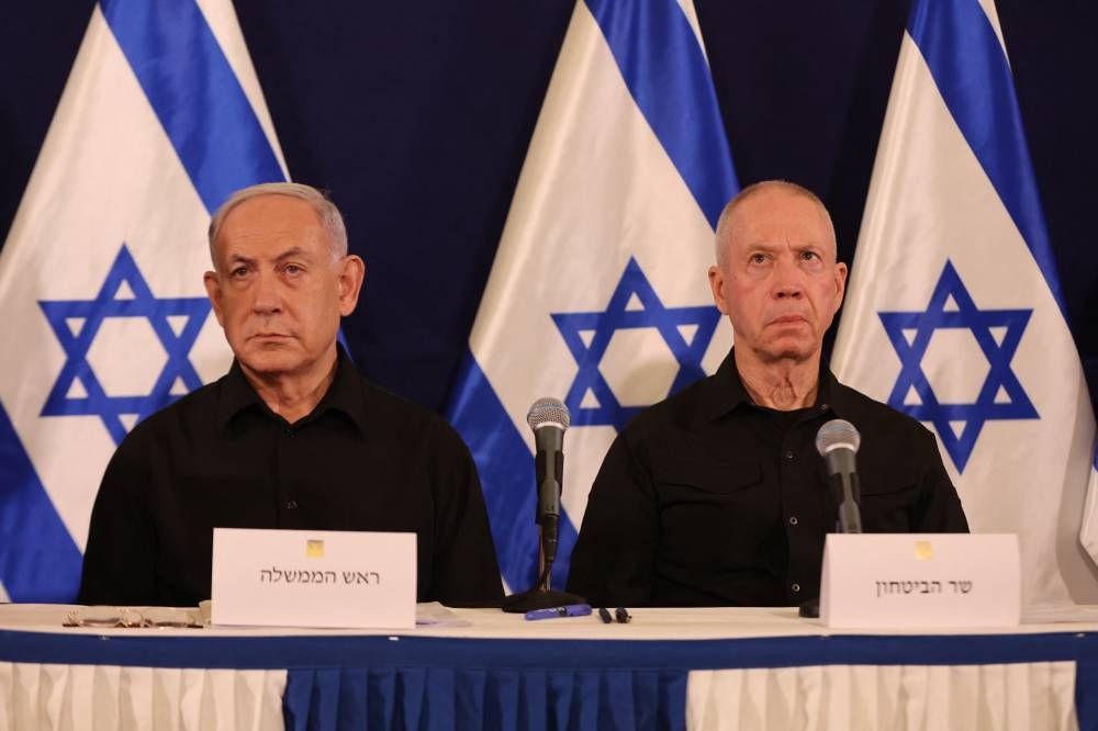 El primer ministro israelí, Benjamin Netanyahu izq., y el ministro de Defensa, Yoav Gallant, asisten a una conferencia de prensa en la base militar de Kirya en Tel Aviv el 28 de octubre de 2023 en medio de las continuas batallas entre Israel y el grupo palestino Hamás. /Foto de Abir SULTAN / POOL / AFP,image_description: