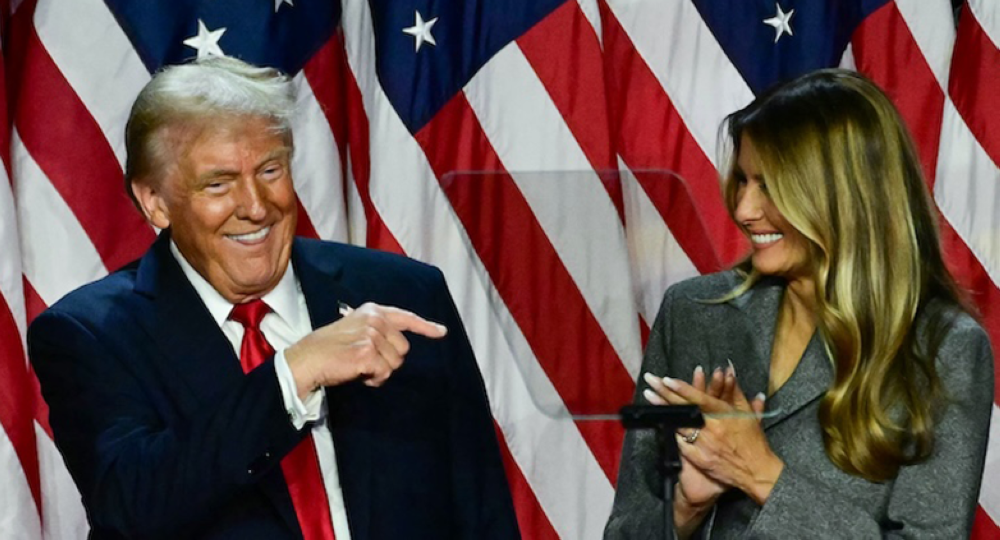 El presidente electo de Estados Unidos, Donald Trump señala a su esposa, la ex primera dama estadounidense Melania Trump, durante una celebración en el Centro de Convenciones de West Palm Beach en West Palm Beach, Florida, la madrugada de este miércoles 6 de noviembre de 2024./ AFP,image_description: