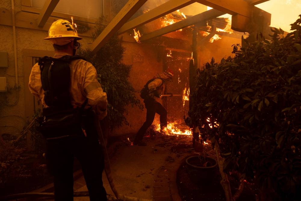 Los bomberos lanzaron agua desde helicópteros durante toda la noche, y varios equipos intentan contener el fuego por tierra, sin embargo fuertes vientos y la baja humedad complican la situación. /AFPn,image_description: