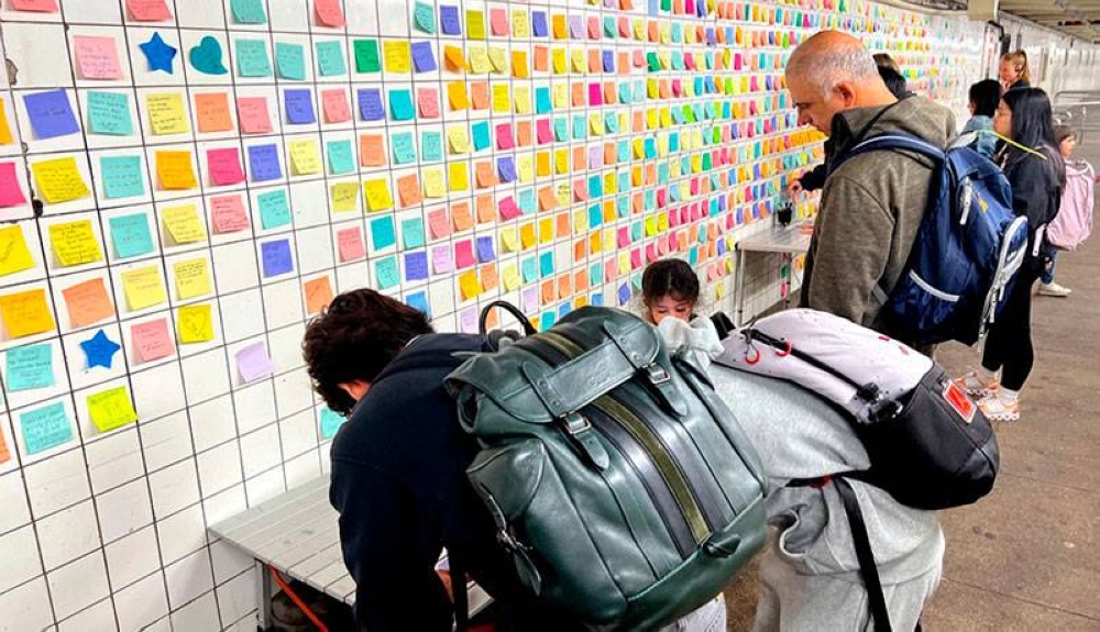 Los usuarios del metro se toman su tiempo para escribir sus pensamientos a modo de terapia. / AFP