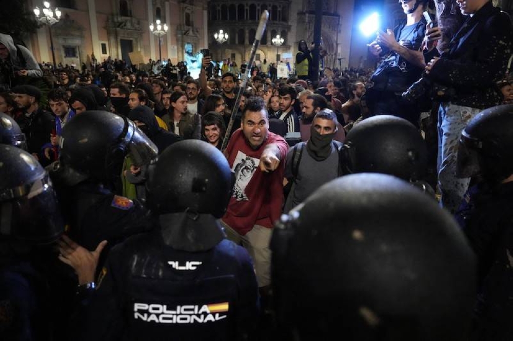 Los manifestantes confrontaron a los policías al pedir la renuncia del presidente de Valencia Carlos Mazon. / AFP.,image_description: