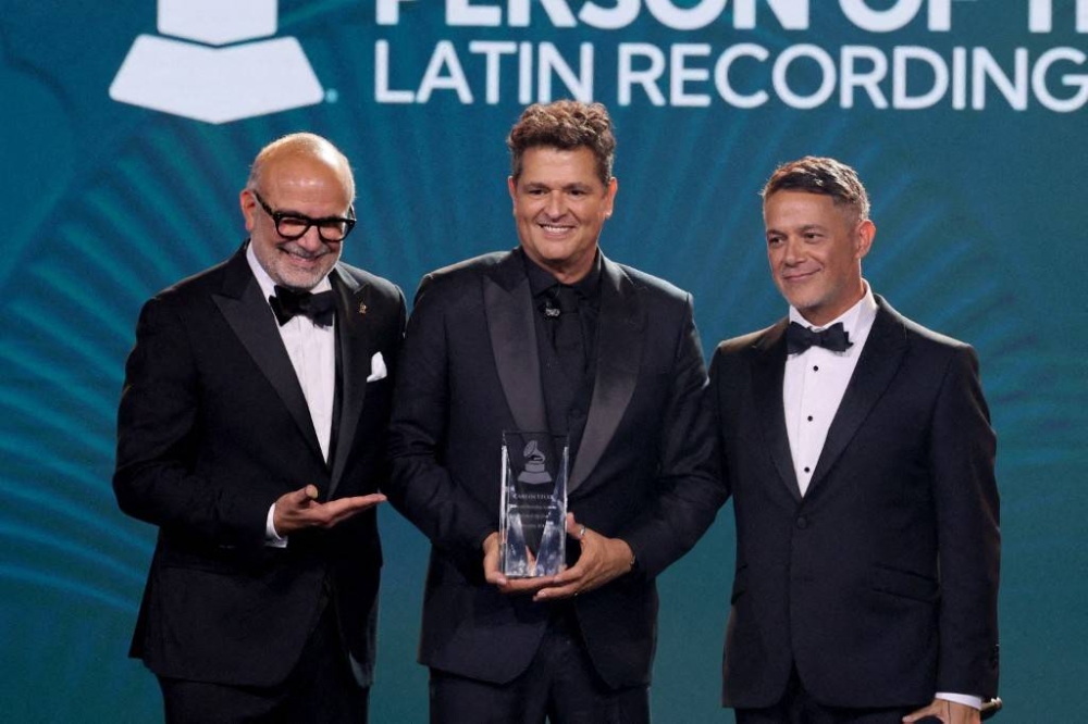 Manuel Abud, CEO de la Latin Recording Academy el cantante colombiano Carlos Vives y su colega español Alejandro Sanz en Miami Beach este miércoles 13 de noviembre. Photo by Dia Dipasupil / GETTY IMAGES NORTH AMERICA / Getty Images via AFP,image_description:2024 Latin Recording Academy Person of The Year Honoring Carlos Vives  Show