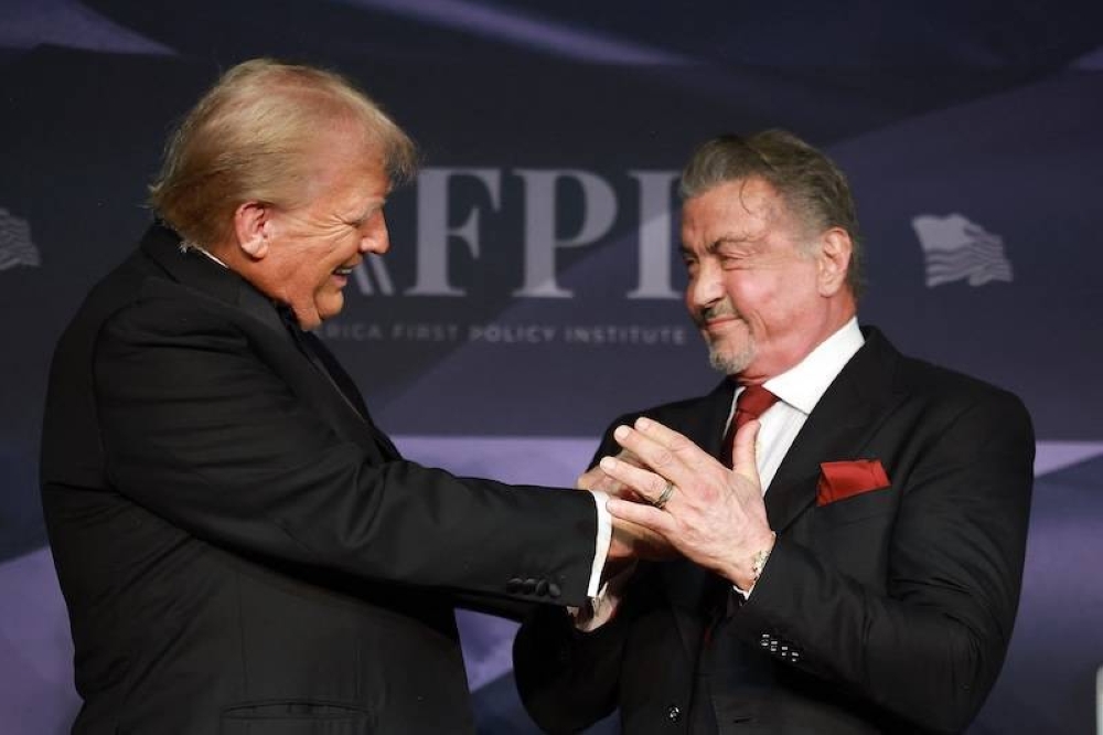 El presidente electo de Estados Unidos, Donald Trump, saluda al actor Sylvester Stallone en el escenario de la Gala del America First Policy Institute celebrada en MaraLago la noche del jueves 14 de noviembre en Palm Beach, Florida./AFP,image_description:PresidentElect Donald Trump Speaks At The America First Policy Institute Gala At MarALago