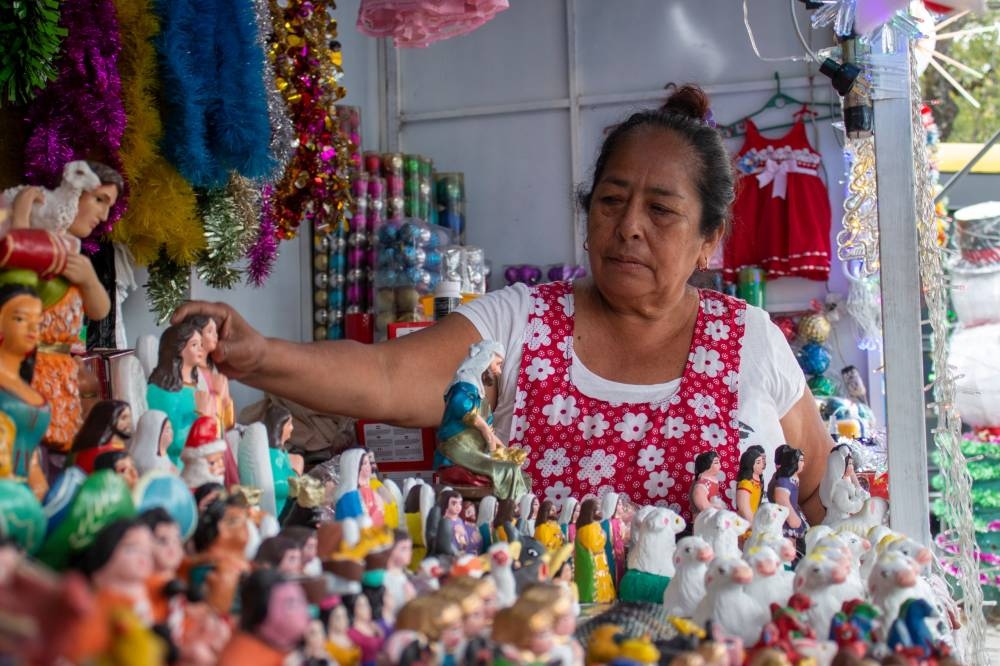 Blanca Estela Giménez es una comerciante que ofrece figuras que adornan los tradicionales nacimiento en la época de navidad. / Libeth Ayala ,image_description: