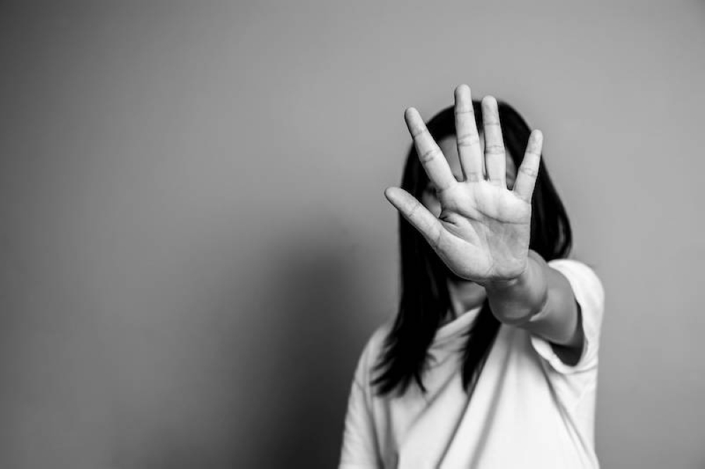 ONU Mujeres registró 51,100 feminicidios durante el 2023.,image_description:woman raised her hand for dissuade, campaign stop violence against women. Asian woman raised her hand for dissuade with copy space, black and white color