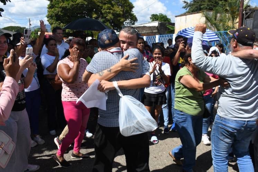 Un hombre arrestado durante las protestas tras el fraude electoral del 28 de julio abraza a un familiar el sábado después de su liberación afuera de la prisión de Tocuyito en Tocuyito, estado de Carabobo, Venezuela. /AFP,image_description: