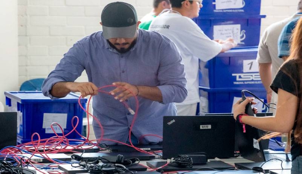 Técnicos informáticos verifican equipo previo a las elecciones 2024. / TSE,image_description: