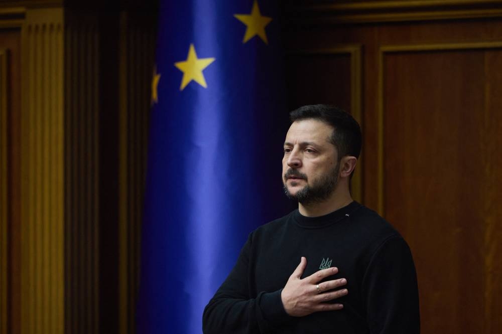 El presidente de Ucrania, Volodímir Zelenski, escucha el himno nacional de Ucrania antes de su discurso ante los miembros del parlamento ucraniano en Kyiv/ Foto AFP.,image_description: