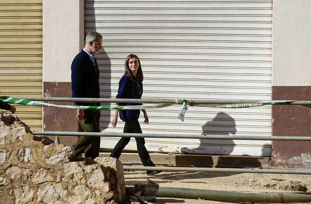 El rey Felipe VI y la reina Letizia de España recorren la localidad de Chiva, en la región de Valencia, al este de España, tras las devastadoras inundaciones mortales ocurridas/ Foto José Jordán AFP.,image_description: