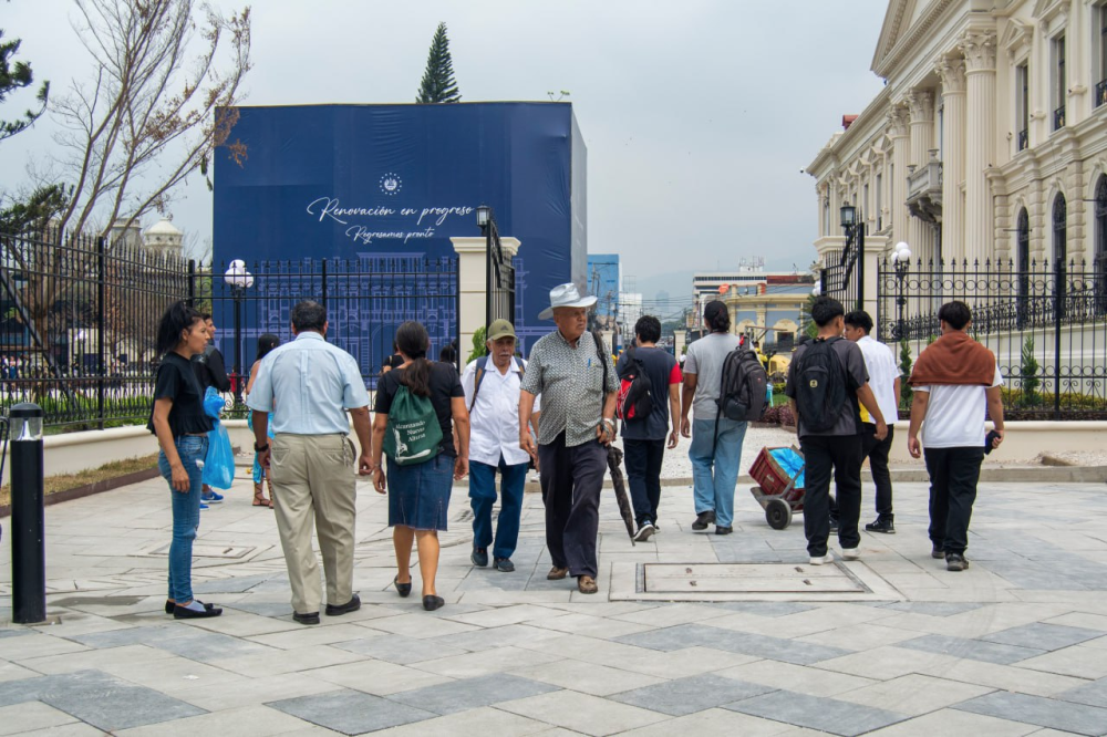 Varios salvadoreños pasean entre la plaza Centroamérica, habilitada desde junio de 2024, y el Palacio Nacional, en el Centro Histórico de San Salvador. El uso y el goce de los bienes culturales podrá permitir la intervención. / Lisbeth Ayala.,image_description: