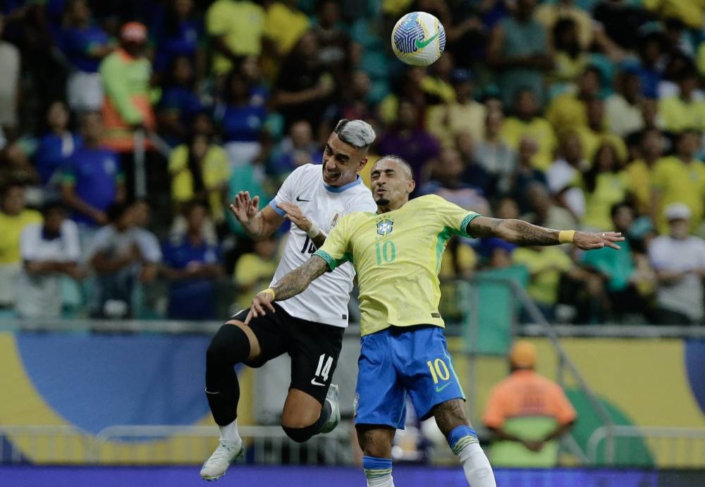 El uruguayo José Luis Rodríguez pelea con el brasileño Raphinha por la pelota. / AFP,image_description: