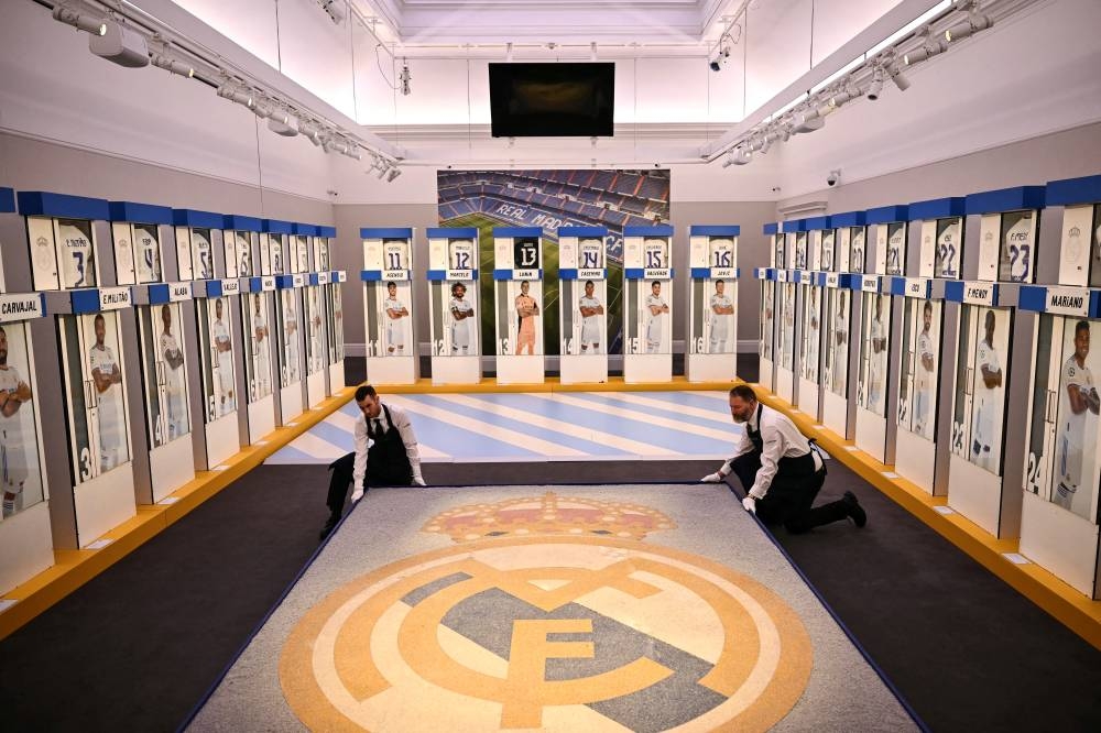 Empleados de la casa subastadora Sotheby039s arreglan un mosaico del Real Madrid. Todo ese será subastado. AFP,image_description: