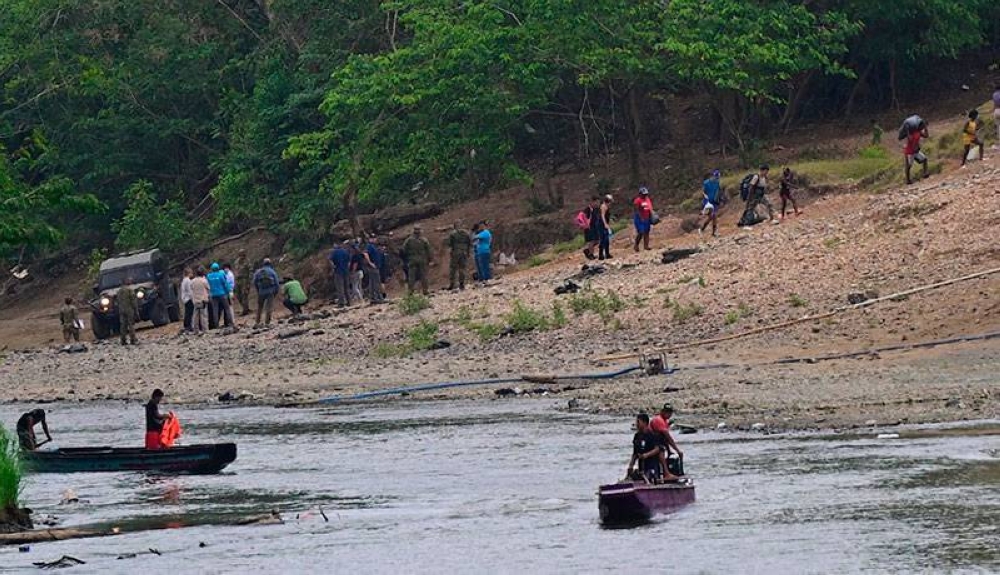 Migrantes llegan a la Estación de Recepción Migratoria en Lajas Blancas, provincia del Darién, en Panamá. / AFP ,image_description: