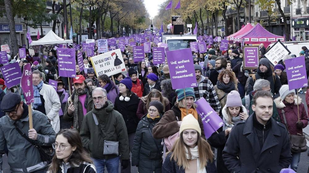 Manifestantes sostienen carteles mientras caminan durante una protesta para condenar la violencia contra las mujeres, convocada por organizaciones feministas dos días antes del día internacional para la eliminación de la violencia contra las mujeres, en París, el 23 de noviembre de 2024. Foto de STEPHANE DE SAKUTIN / AFP,image_description: