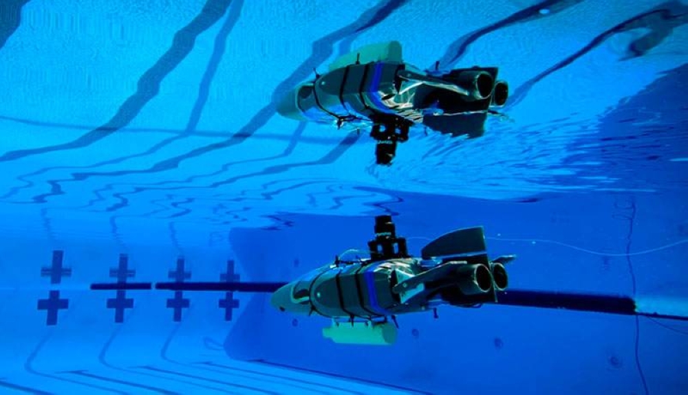 Un prototipo de robot diseñado para explorar los océanos subterráneos de las lunas heladas se refleja en la superficie del agua durante una prueba en una piscina en Caltech en septiembre. / NASA,image_description: