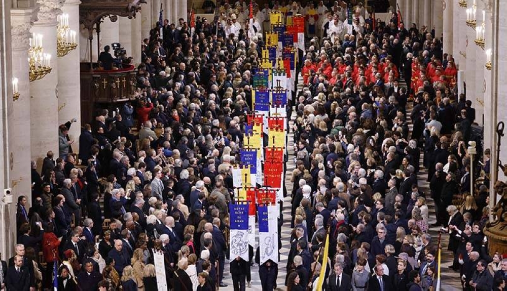 Los invitados observan el desfile de estandartes de la iglesia durante la ceremonia de conmemoración. /AFP