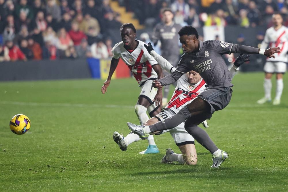 Vinicius Junior remata ante la marca de Ivan Balliu, del Rayo Vallecano. / AFP,image_description: