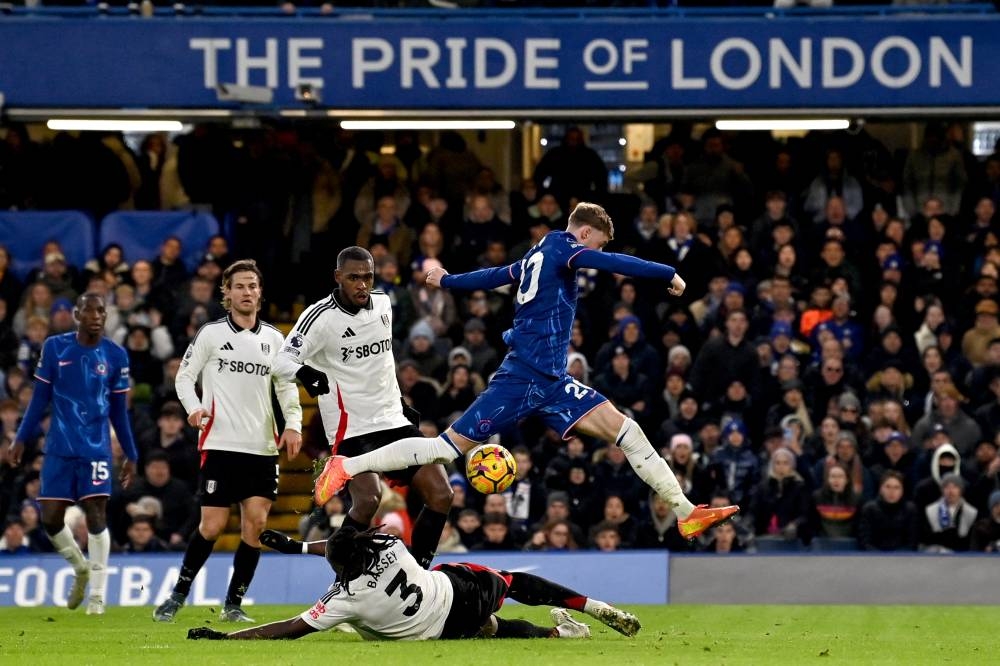 Cole Palmer, del Chelsea, salta por encima de Calvin Bassey, del Fulham. / AFP,image_description: