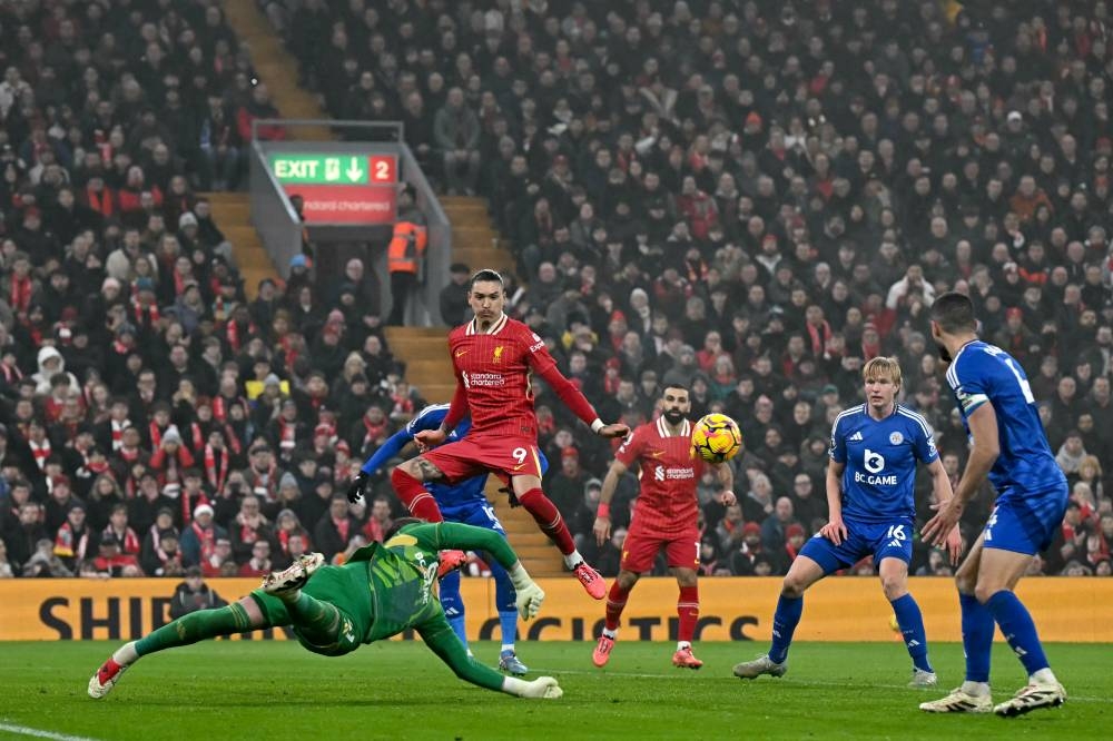 El portero Jakub Stolarczyk, de Leicester, rechaza el balón ante la presencia del delantero Darwin Núñez, del Liverpool. / AFP,image_description: