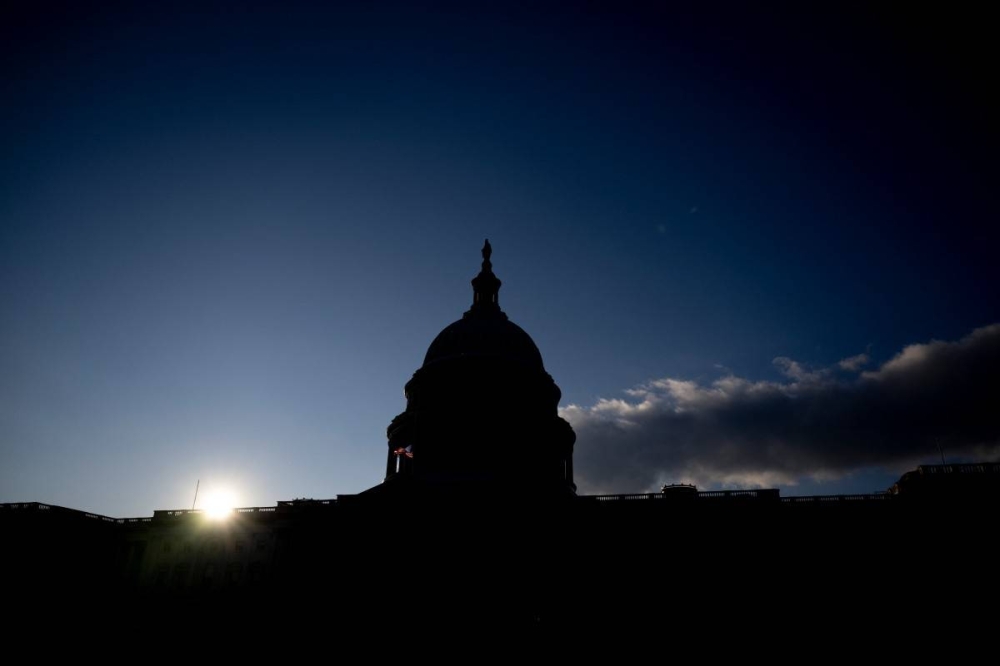 El sol se pone sobre el Capitolio de Estados Unidos en Washington, DC, el 2 de enero de 2025. ROBERTO SCHMIDT / AFP,image_description: