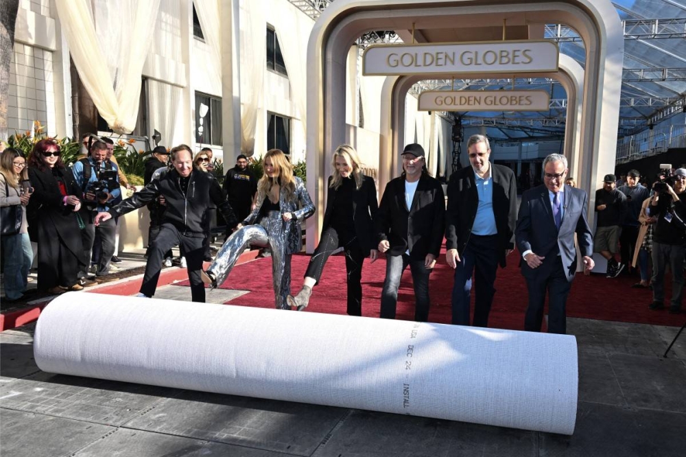 El productor ejecutivo Barry Adelman, la host Nikki Glaser, la presidenta de los Globos de Oro Helen Hoehne Glenn Weiss y Ricky Kirshner desenrollaron la alfombra roja este 2 de enero en el hotel Beverly Hilton de Beverly Hills. Photo by Robyn Beck / AFP,image_description:Preparations are underway on the Golden Globes red carpet one day ahead of the Hollywood award season first ceremony