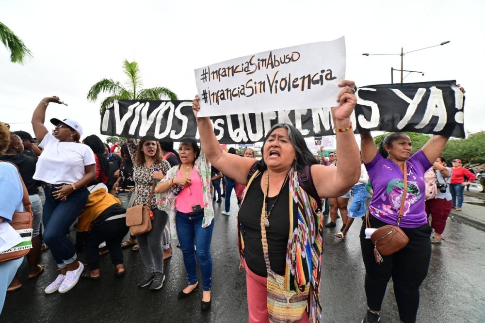 La gente se manifiesta contra la desaparición de cuatro menores de edad que desaparecieron durante un operativo militar, frente al palacio de justicia de Guayaquil, Ecuador, el 31 de diciembre de 2024, durante la audiencia de acusación formal contra 16 militares presuntamente implicados en la desaparición. /AFP,image_description: