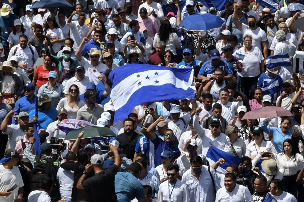 Manifestantes con una bandera de Honduras. /Fotografía ilustrativa. AFP,image_description: