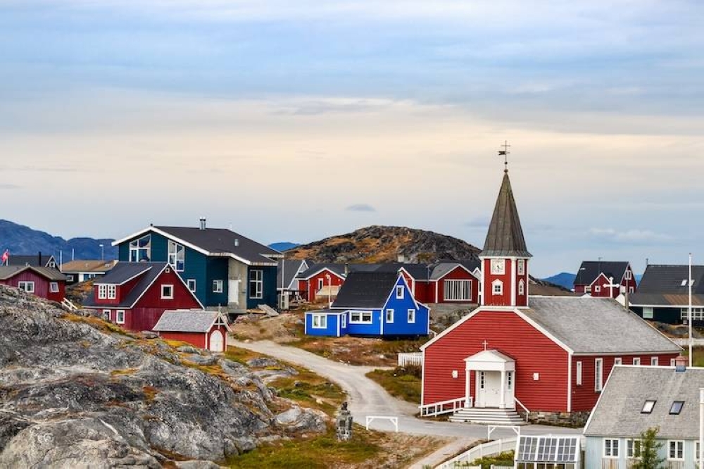 La Catedral de Nuestro Salvador Annaassisitta Oqaluffia y las casas coloridas al fondo en Nuuk, la capital de Groenlandia.,image_description:The Cathedral of Our Saviour Annaassisitta Oqaluffia and colorful houses in Nuuk.