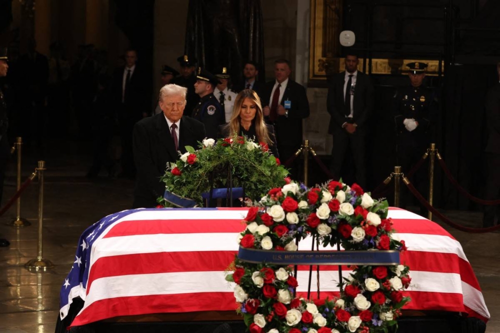 El presidente electo de Estados Unidos, Donald Trump, y la ex primera dama de Estados Unidos, Melania Trump, rinden homenaje frente al ataúd envuelto en la bandera del expresidente Jimmy Carter en la Rotonda del Capitolio de Estados Unidos en Washington, DC, el 8 de enero de 2025./AFP,image_description: